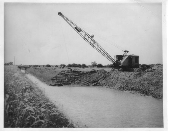 Historic image: an old dragline machine widening a drain to increase the capacity of its drainage capabilities.